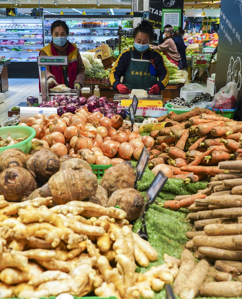 在通化市一家大型连锁超市内,工作人员在蔬菜区补货(1月18日摄).