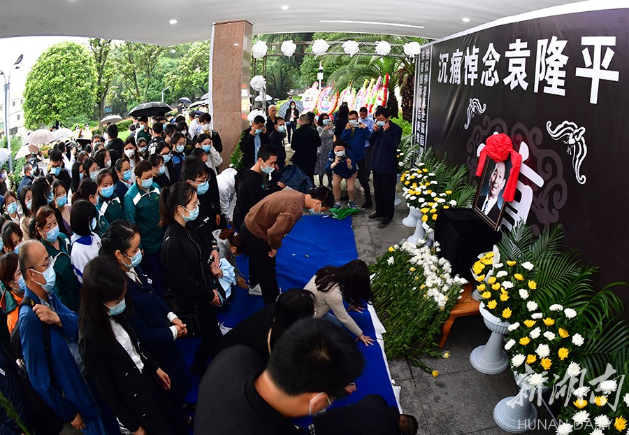 大批群众前往明阳山殡仪馆排长队悼念袁隆平,厅前已成花海