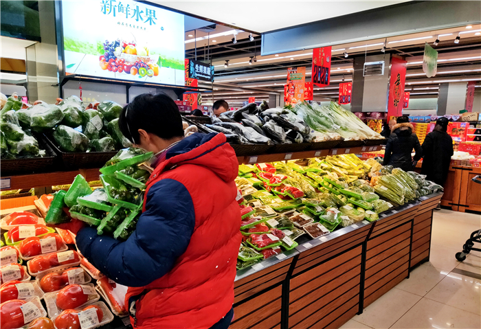 超市工作人员对售空的蔬菜进行补充